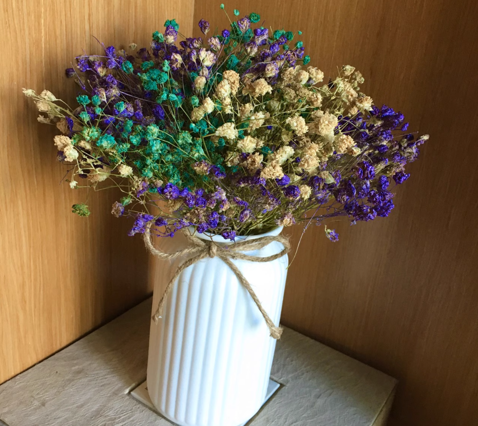 Vit räfflad keramikvas med torkade blommor