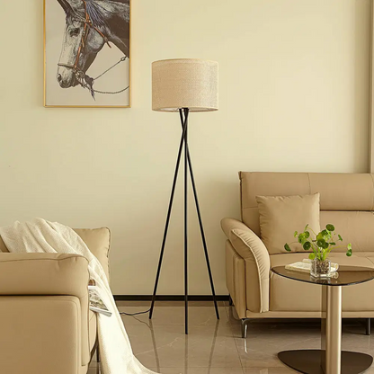 Skandinavisk trebent golvlampa i vardagsrum med beige soffa