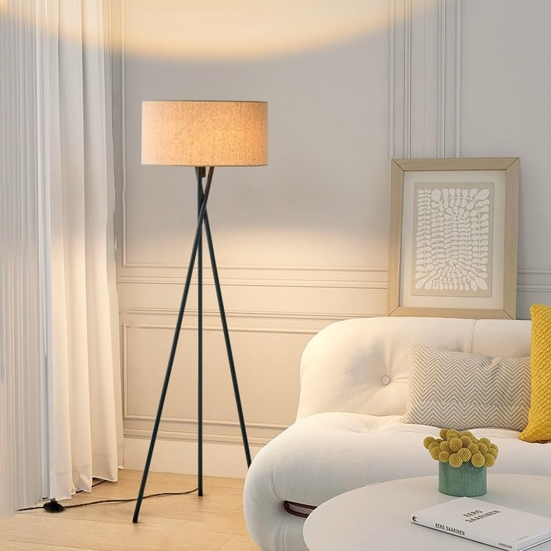 Trebent golvlampa i vardagsrum bredvid vit soffa
