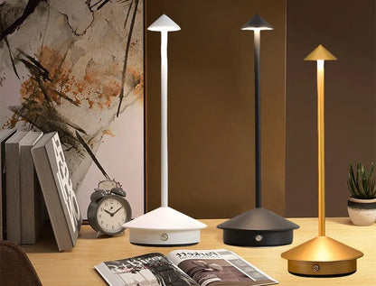 Touch-bordslampa i vit, svart och guld på bokhylla